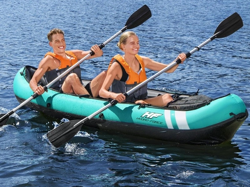 Dos personas remando en un kayak hinchable